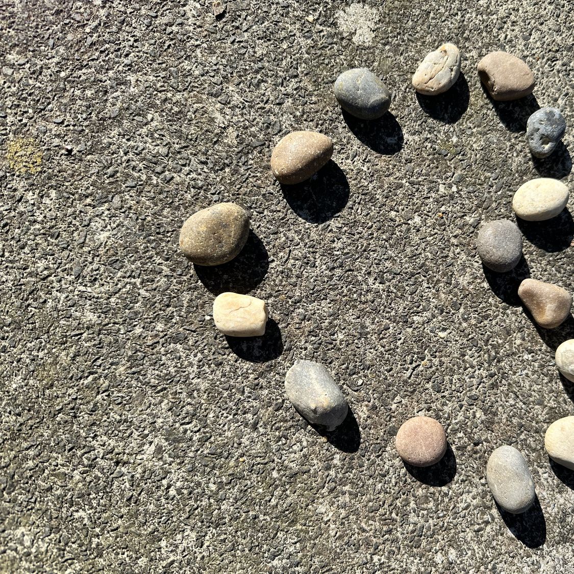 Kleine Steine, die auf dem Sand eines Strandes ein Herz bilden, als Symbol für ein Kennenlernen ab 50, eine dauerhafte Beziehung und geteilte Liebe.