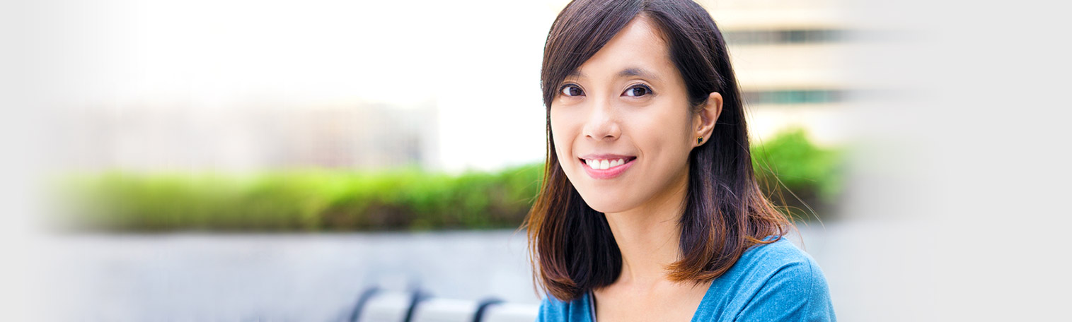Eine asiatische Single-Frau lächelt im Sonnenschein