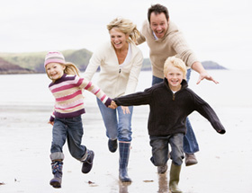 Kinderwunsch: Familie mit zwei Kindern am Strand