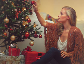 Weihnachten alleinerziehend: Frau allein am Weihnachtsbaum